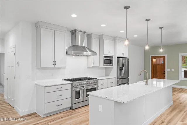 a kitchen with a stove a window and cabinets
