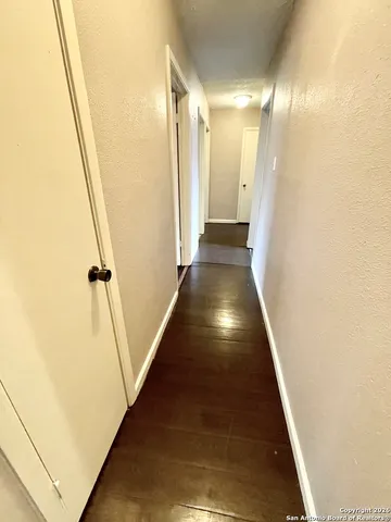 a view of a room with wooden floor and white walls