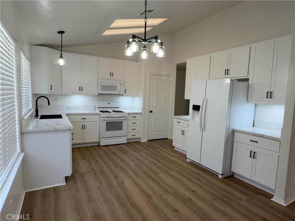 12590 Cobalt Road Victorville, CA 92392 - Photo 17 of 37 a kitchen with kitchen island white cabinets and stainless steel appliances