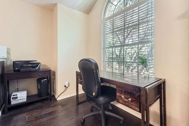a view of a workspace with furniture and a window