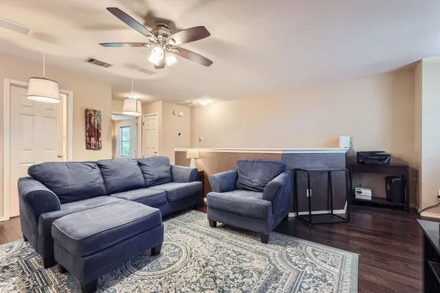 a living room with furniture and a wooden floor