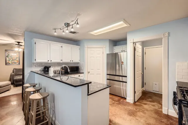 a kitchen with white cabinets and stainless steel appliances