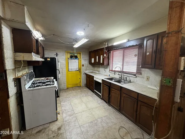 a kitchen with stainless steel appliances granite countertop a stove a sink and a refrigerator