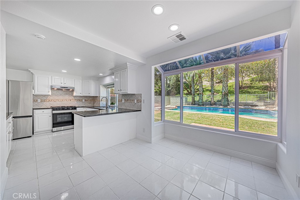 25533 Longfellow Place Stevenson Ranch, CA 91381 - Photo 10 of 47 a large white kitchen with a large window