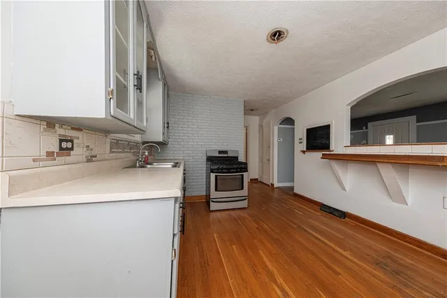 a kitchen with stainless steel appliances granite countertop a sink a stove and a refrigerator