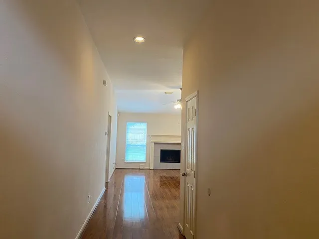a view of a livingroom with wooden floor and a kitchen space