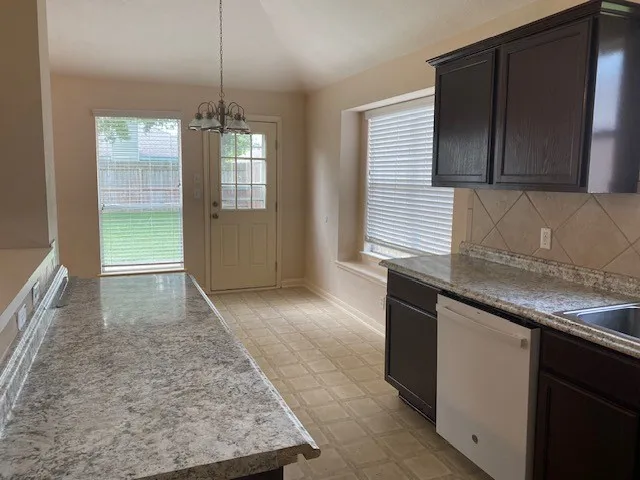 a kitchen with granite countertop a sink and a stove