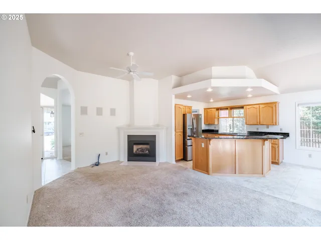a view of open kitchen with granite countertop sink and cabinets
