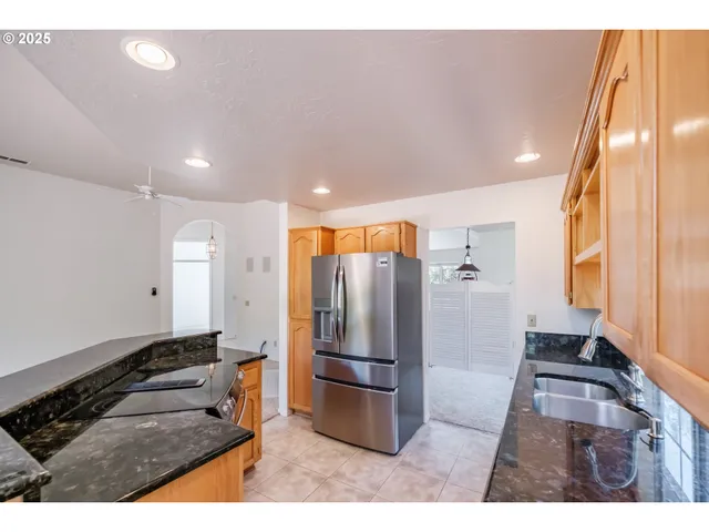 a kitchen with stainless steel appliances granite countertop a refrigerator and a stove