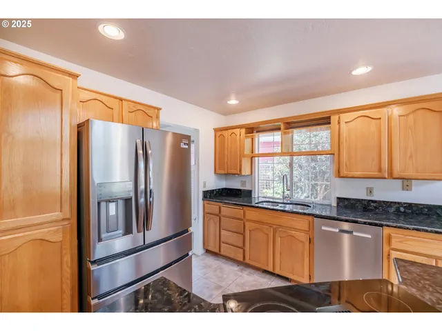 a kitchen with granite countertop a refrigerator and a sink