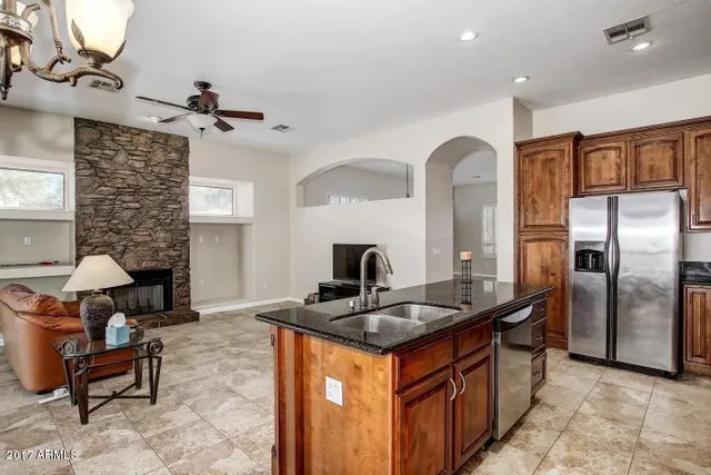 a kitchen with stainless steel appliances granite countertop a sink a stove and a refrigerator