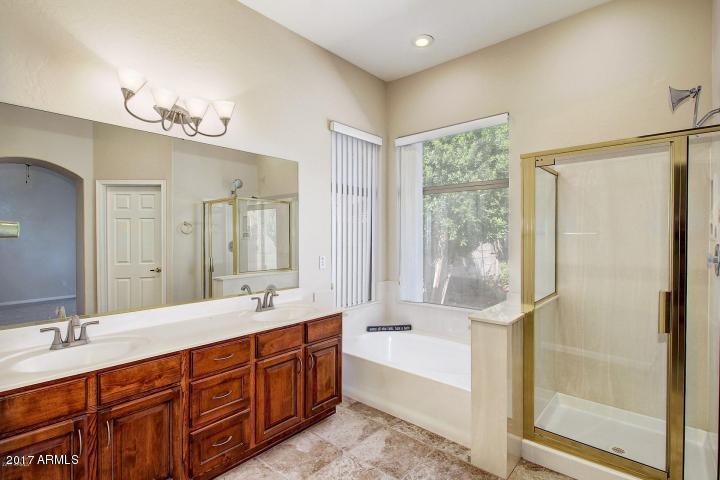 16810 North 62nd Place Scottsdale, AZ 85254 - Photo 18 of 31 a bathroom with double vanity sinks a large mirror and a bathtub