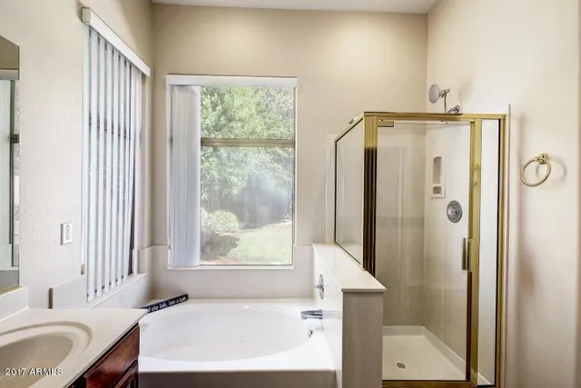 a bathroom with a granite countertop sink and a bathtub