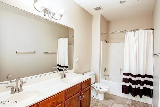 a bathroom with a sink vanity mirror and toilet
