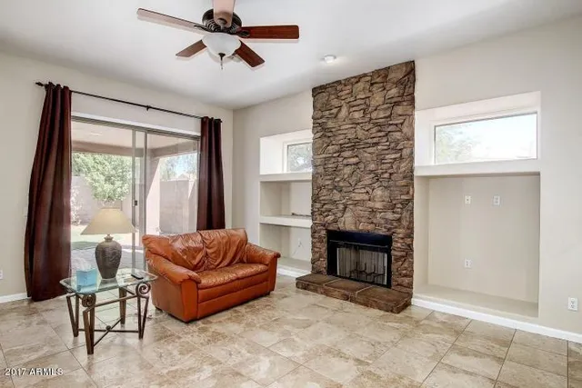 a living room with furniture a fireplace and a window