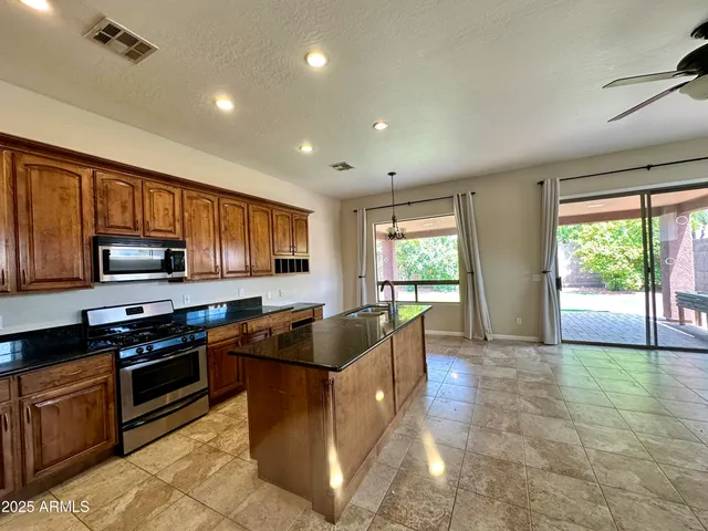 a kitchen with stainless steel appliances granite countertop a sink stove and microwave
