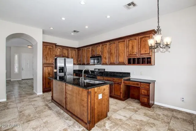 a kitchen with stainless steel appliances granite countertop a refrigerator and a stove top oven