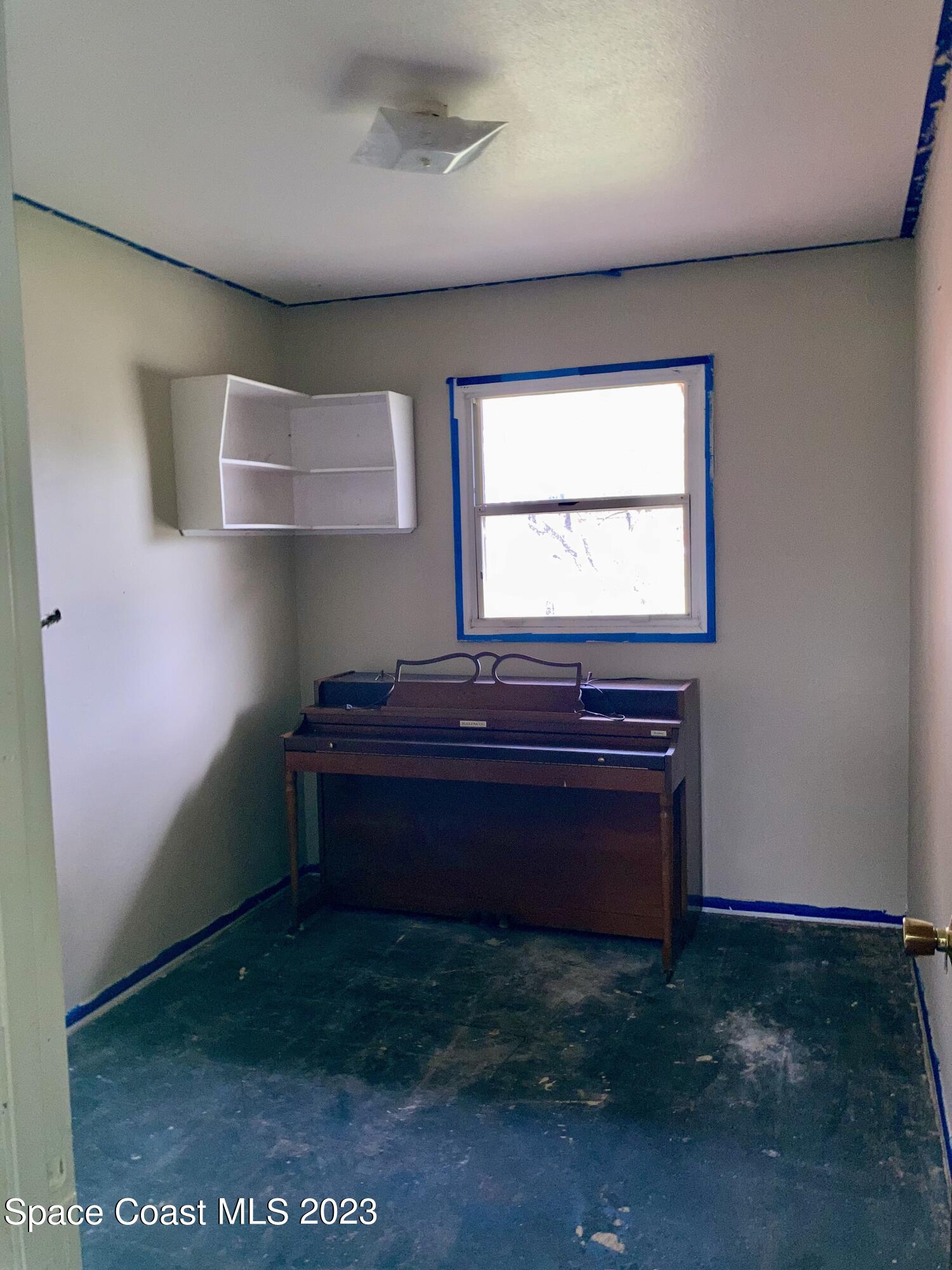 4396 Doncaster Drive Melbourne, FL 32935 - Photo 17 of 22 a room with a piano and wooden floor