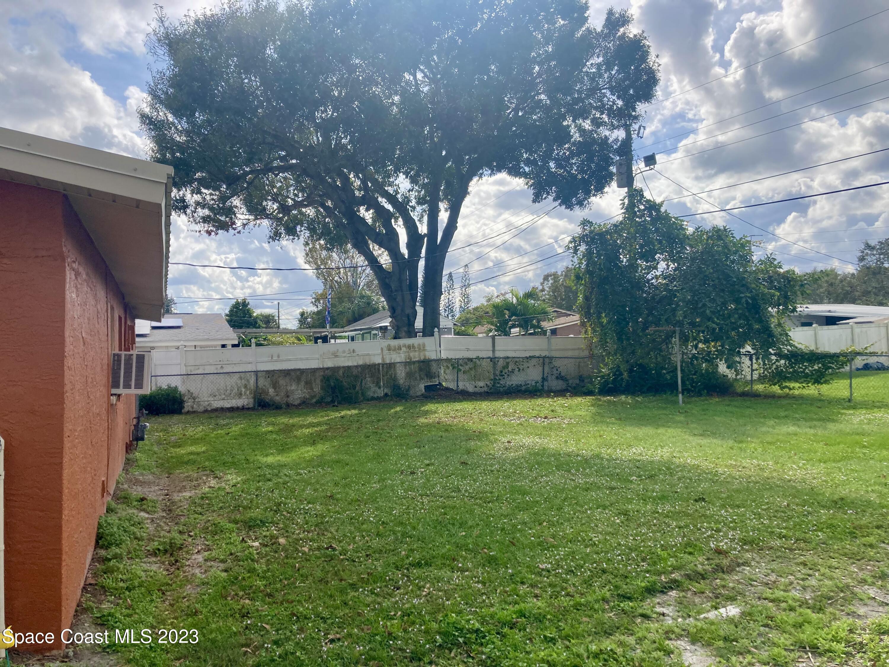 4396 Doncaster Drive Melbourne, FL 32935 - Photo 20 of 22 a backyard of a house with lots of green space and fountain