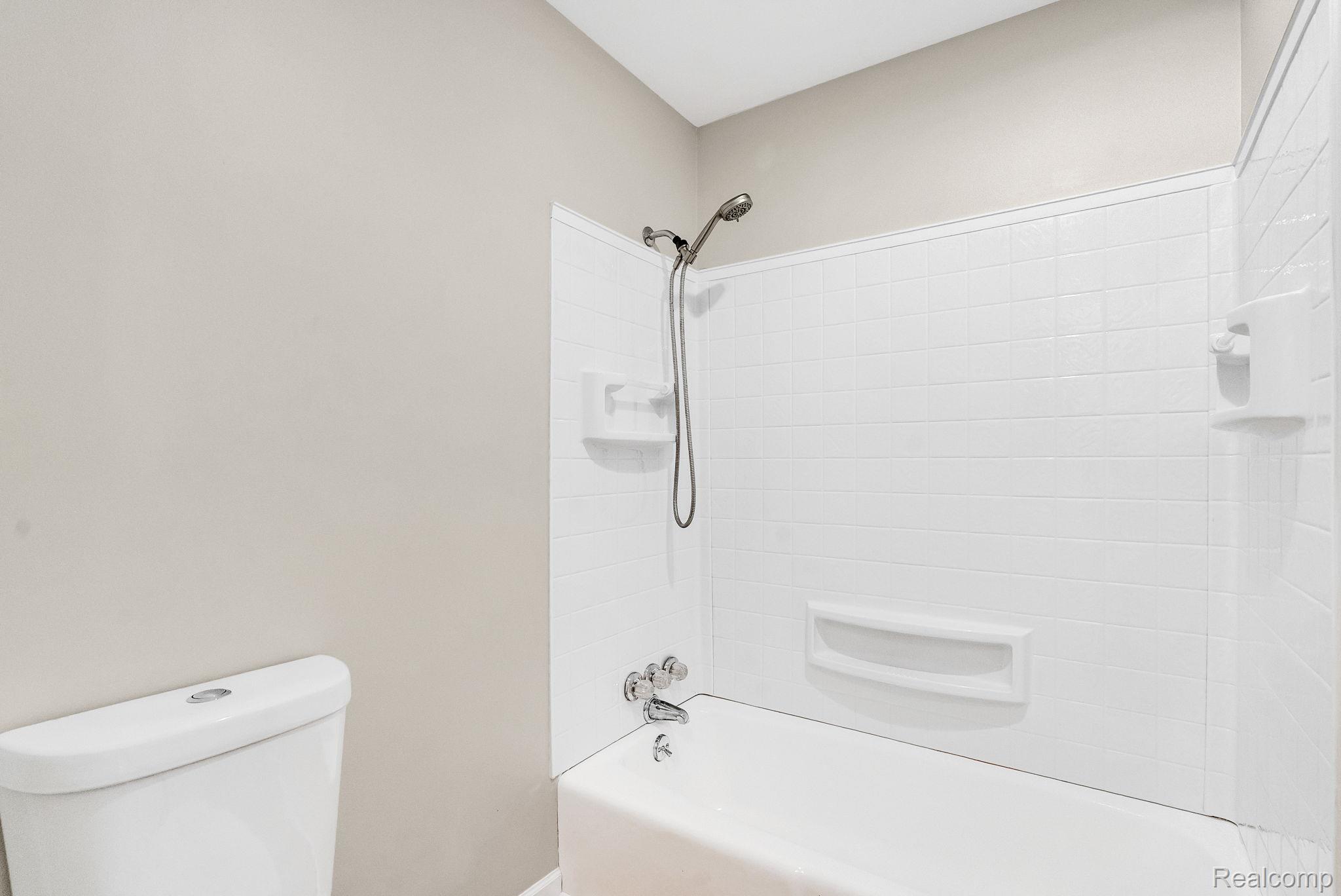 4046 State Road Fort Gratiot, MI 48059 - Photo 28 of 38 White tiled shower and tub combination featuring a handheld showerhead