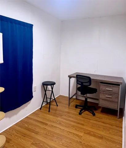 a room with gym equipment and wooden floor
