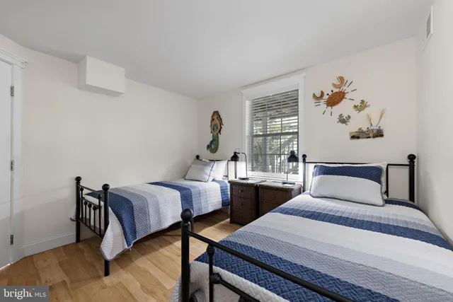 a bedroom with a bed a mirror on dresser and a window