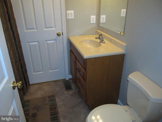 11635 Bald Bluff Road Lusby, MD 20657 - Photo 14 of 19 a bathroom with a sink a toilet and a mirror