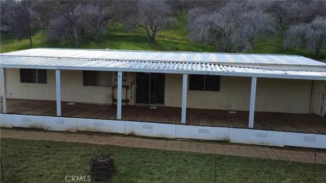 a view of a house with backyard and a tree