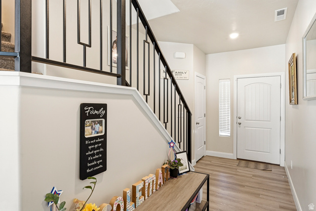 668 East Fiddlers Canyon Road, Unit 6 Cedar City, UT 84721 - Photo 13 of 36 Entryway featuring wood-finish flooring, a white paneled entry door with an arched top panel, and an adjacent vertical window with blinds
