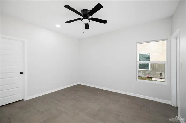an empty room with a window and a fan