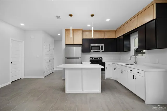 a large kitchen with stainless steel appliances lots of counter space and a sink