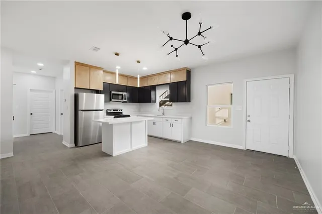 a view of a kitchen with stainless steel appliances a refrigerator and a sink