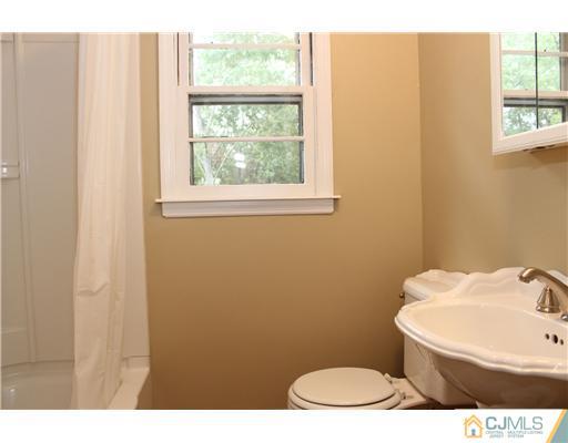 176 Kimberly Road Colonia, NJ 07067 - Photo 17 of 22 a bathroom with a toilet a sink and a window