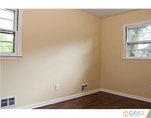 176 Kimberly Road Colonia, NJ 07067 - Photo 18 of 22 an empty room with wooden floor and windows