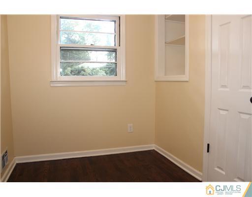 176 Kimberly Road Colonia, NJ 07067 - Photo 19 of 22 an empty room with wooden floor and windows