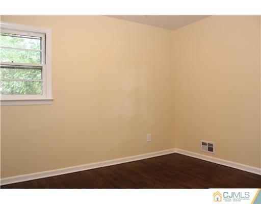 176 Kimberly Road Colonia, NJ 07067 - Photo 20 of 22 an empty room with wooden floor and windows