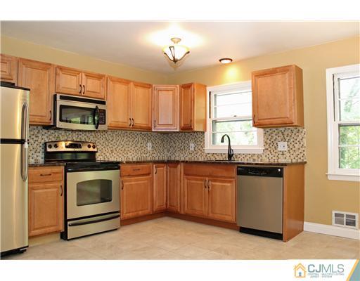 176 Kimberly Road Colonia, NJ 07067 - Photo 5 of 22 a kitchen with stainless steel appliances granite countertop a sink a stove a microwave a refrigerator a sink and dishwasher with wooden floor