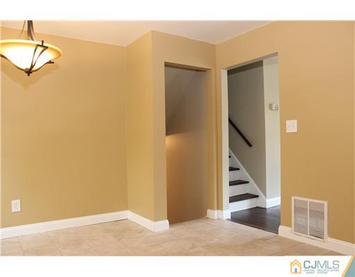 176 Kimberly Road Colonia, NJ 07067 - Photo 8 of 22 a view of a hallway with wooden floor and staircase