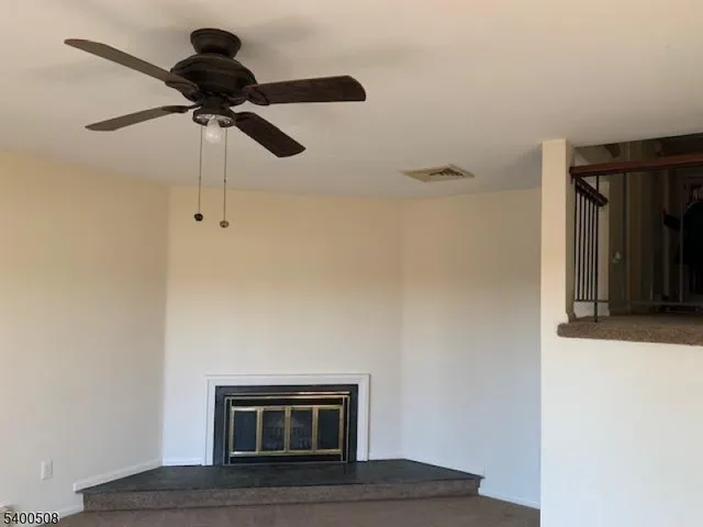 a living room with a ceiling fan and a wooden floor