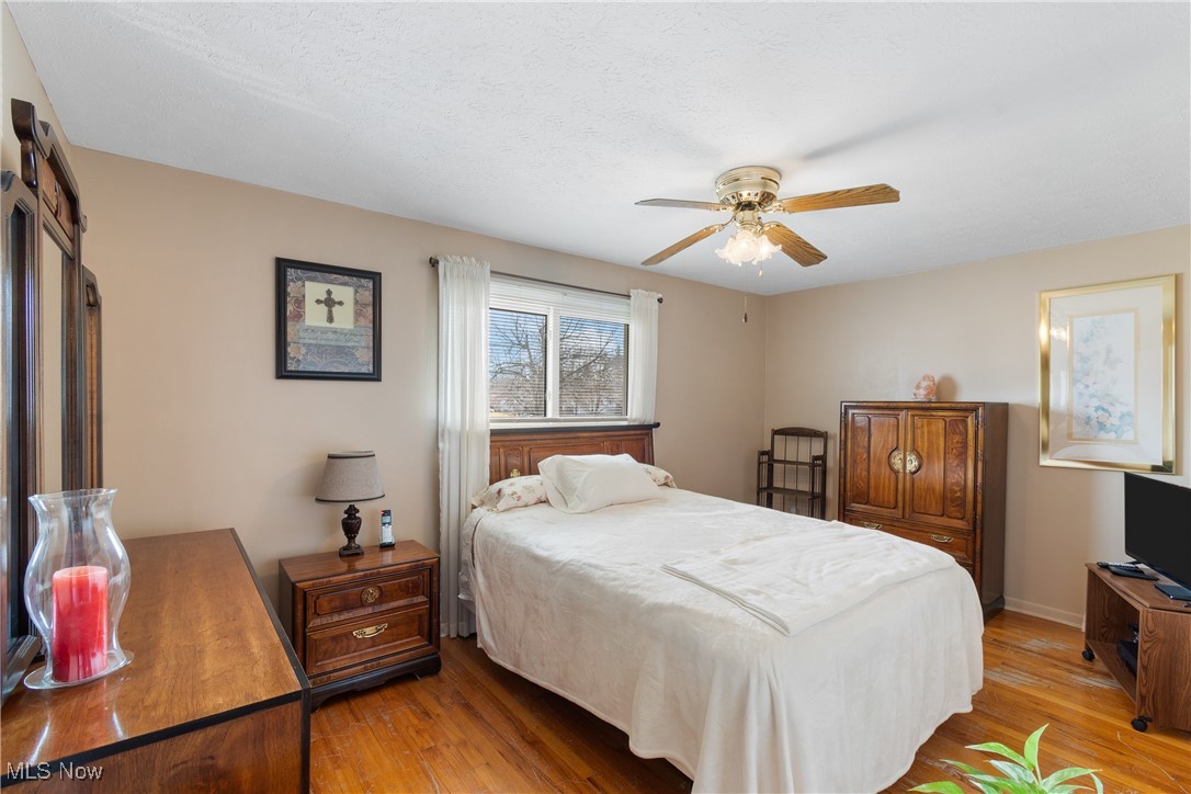 447 Center Road Bedford, OH 44146 - Photo 17 of 33 Bedroom featuring a ceiling fan, light wood-style flooring, and baseboards
