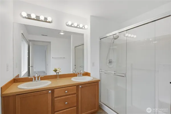 a bathroom with a granite countertop sink a mirror and shower