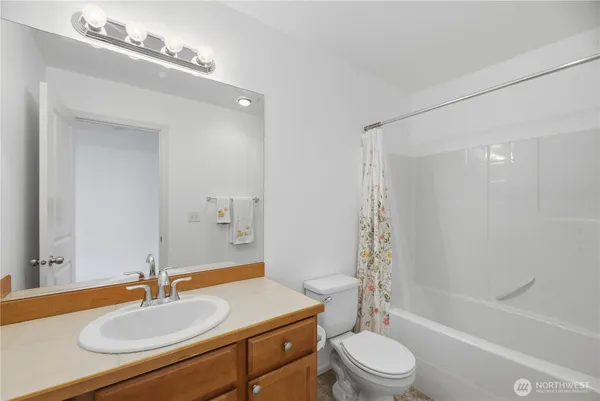 a bathroom with a sink a toilet a mirror and shower