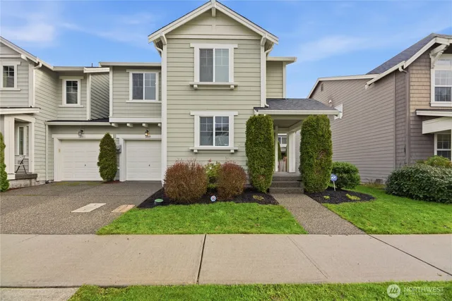 a front view of a house with a yard and a garage