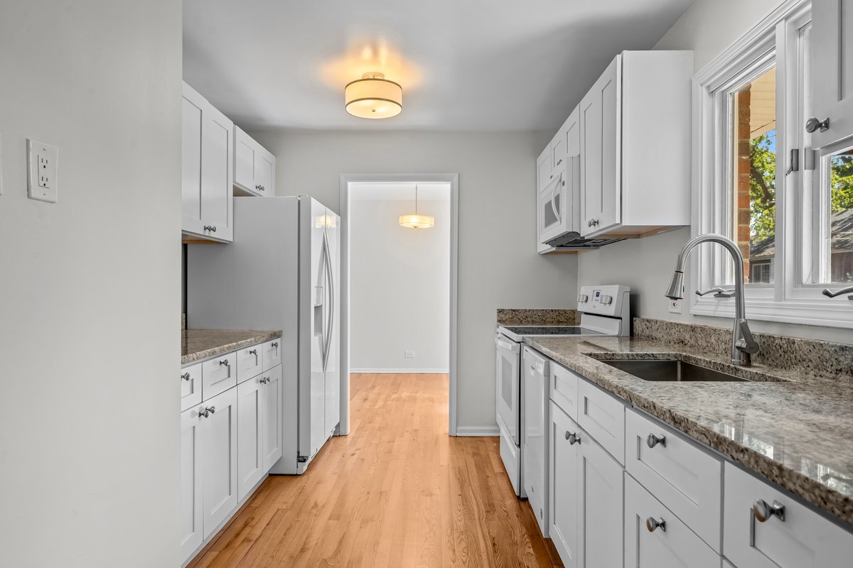 2500 Green Bay Road Highland Park, IL 60035 - Photo 7 of 18 a kitchen with granite countertop a sink stainless steel appliances white cabinets and wooden floor