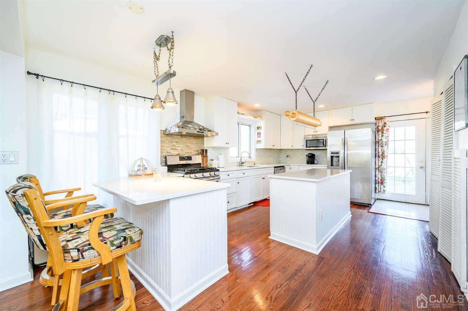 31 Parker Road Long Valley, NJ 07853 - Photo 14 of 46 a kitchen with a sink dishwasher a stove a dining table and chairs with wooden floor