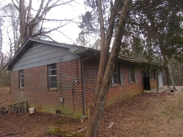 a view of a house with a yard and large tree