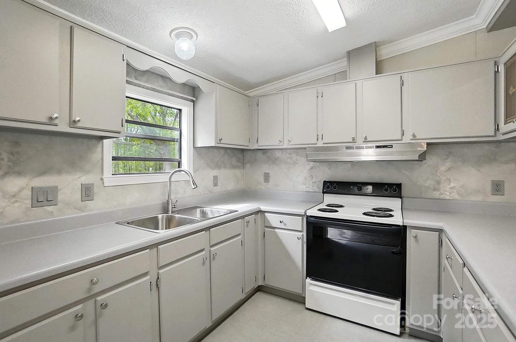 621 Harper Davis Road Lake Wylie, SC 29710 - Photo 12 of 30 a kitchen with white cabinets appliances a sink and a window