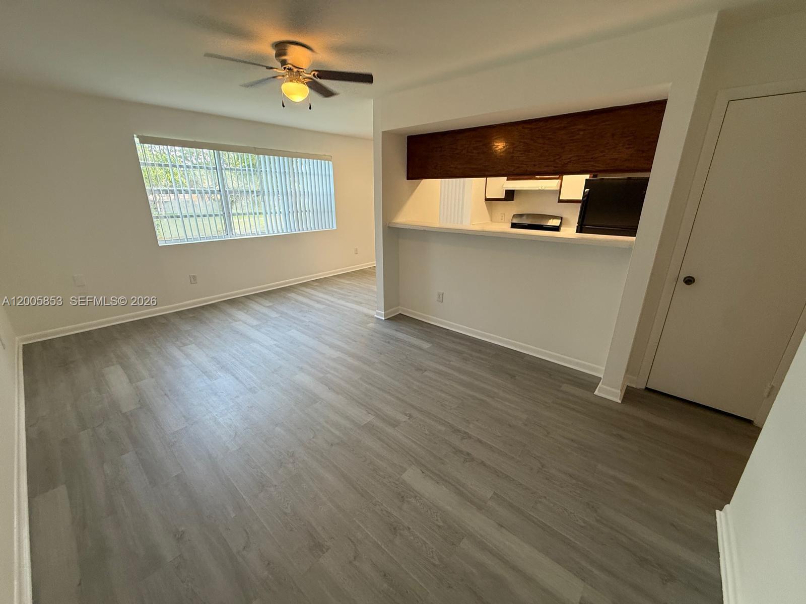 15285 Southwest 107th Lane, Unit 214 Miami, FL 33196 - Photo 1 of 16 wooden floor in an empty room with a window