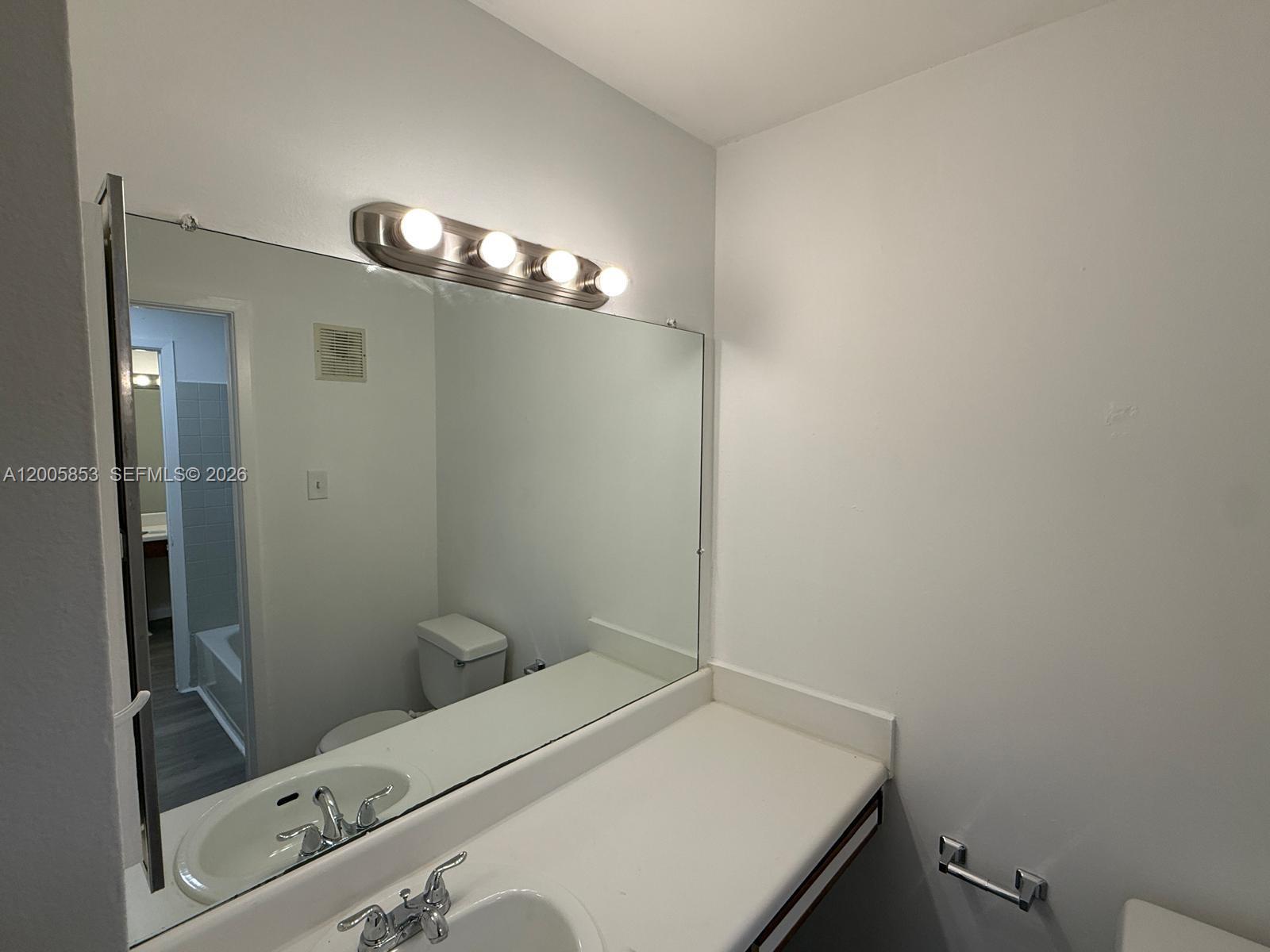 15285 Southwest 107th Lane, Unit 214 Miami, FL 33196 - Photo 11 of 16 a bathroom with a sink and a mirror