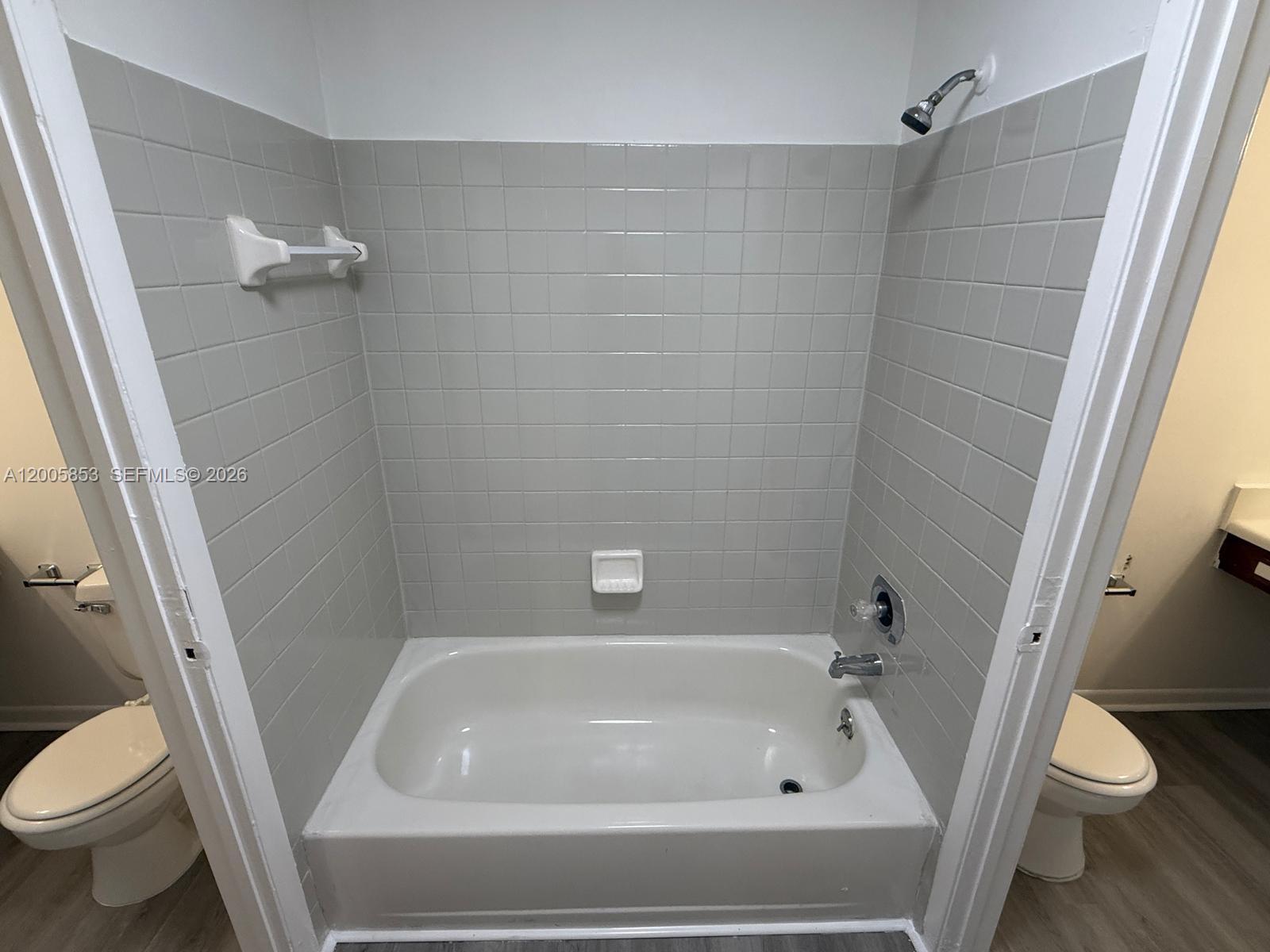 15285 Southwest 107th Lane, Unit 214 Miami, FL 33196 - Photo 12 of 16 a white bath tub sitting next to a toilet